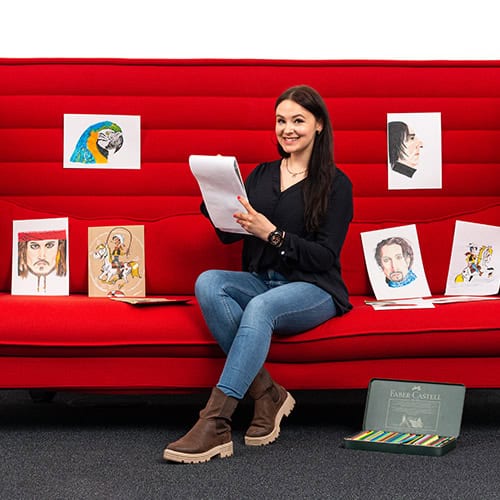 Frau sitzt auf rotem Sofa mit Clarity Software Screenshots und Zeichnungen.